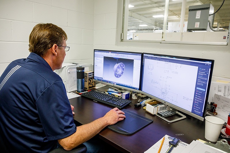 person creating 3D parts on a computer program
