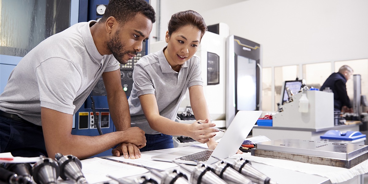 Two Engineers Using CAD Programming Software On Laptop